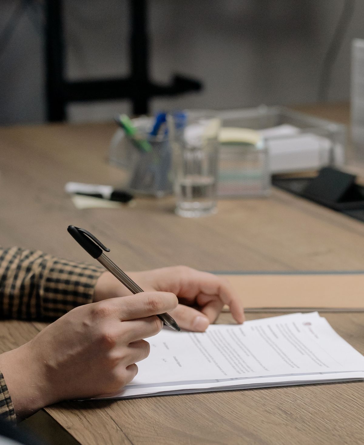 Hands reviewing paperwork at a kitchen table